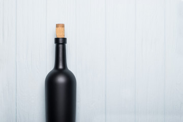 Wine bottle on white wooden background. Mock-up