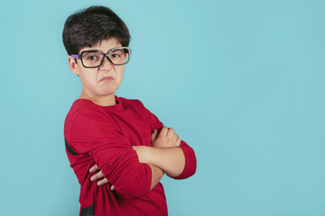 niño enfadado con gafas sobre fondo azul
