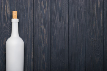 Wine bottle on dark wooden background. Mock-up