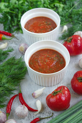 Spicy tomato sauce with herbs, Ketchup, Cooking, Summer mood on a gray background