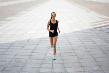 Fototapeta na wymiar Young woman running in city copy space