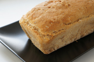Part of white bread on black plate