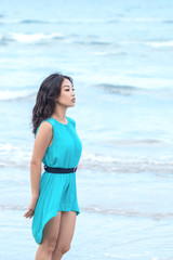 Fototapeta na wymiar Young beautiful asian woman is walking along the beach