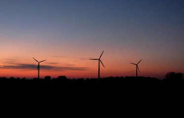 Fototapeta na wymiar Drei Windkraftwerke am Abend