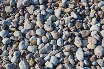 From above shot of smooth rocks lying on coast on sunny day. 