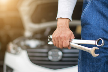 Hand of car mechanic with wrench. Auto repair garage.