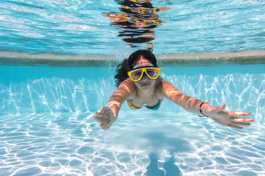 Girl in mask dive in swimming pool
