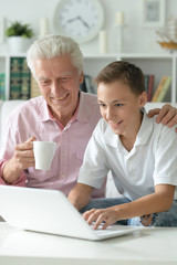 portrait of boy and grandfather with a laptop