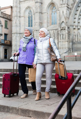Senior females walking with baggage on city