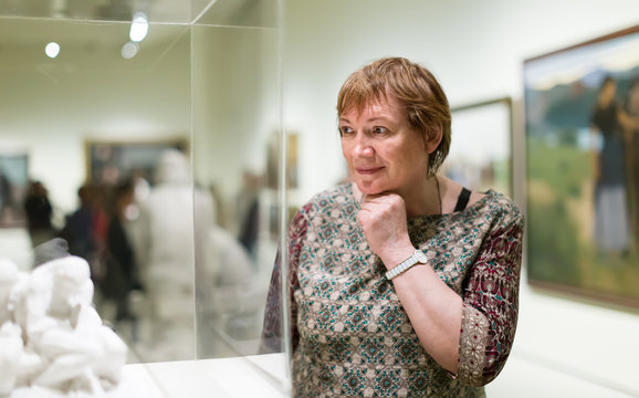 Woman visiting museum and enjoying sculture