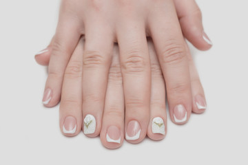 Fototapeta premium Light manicure in light on a white background.