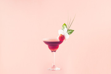 Mocktail decorated with strawberry, flower and tropical leaves.