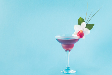 Mocktail decorated with strawberry, flower and tropical leaves.