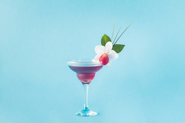Mocktail decorated with strawberry, flower and tropical leaves.
