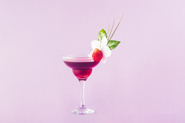 Mocktail decorated with strawberry, flower and tropical leaves.