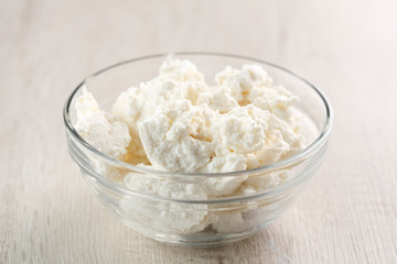 homemade Ricotta cheese in glass bowl on wooden table