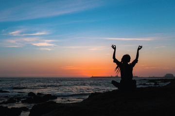 Fototapeta premium Yoga silhouette meditation woman on the ocean during amazing sunset.