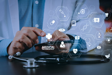 close up of smart medical doctor working with smart phone and stethoscope on dark wooden desk