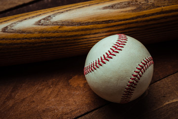 A group of vintage baseball equipment, bat, baseball on wooden background