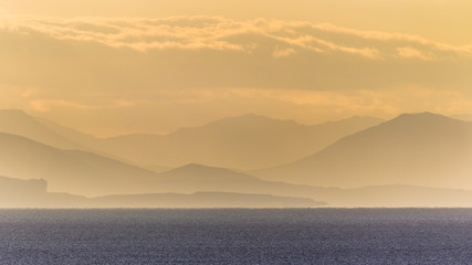 Fototapeta na wymiar Silhouettes of hills over ocean