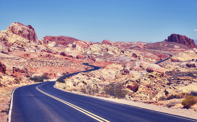 Vintage toned deserted road, travel concept, Valley of Fire, Nevada, USA.