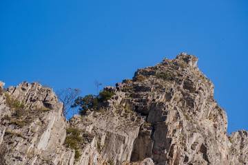 Young man lead climbing on cliff