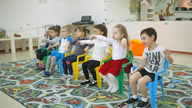 Children's developing a game room. Emotions of young children during entertaining classes. child is building a cheerful expression. antics, Children build funny faces. People make the ears of the