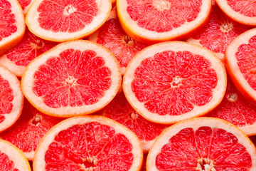 Grapefruit red juicy slices background. top view