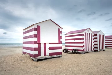 Schilderijen op glas Rij kleurrijke strandhuisjes op een bewolkte dag © Erik_AJV