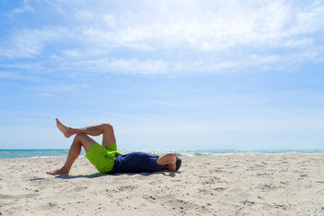 man laying on his back on beach