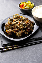 Roasted beef in sauce with spices and sesame seeds in Asian style. Mongolian meat.