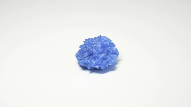 Macro shot of chalcanthite mineral isolated over white background and spinning around
