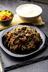 Roasted beef in sauce with spices and sesame seeds in Asian style. Mongolian meat.