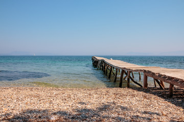 Fototapeta premium old jetty walkway pier and the sea. Stones beach. adventure Travel concept. wild beach. Copy space