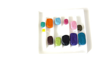 multi-colored pieces of plasticine for children's modeling in a box of different sizes on a white isolated background