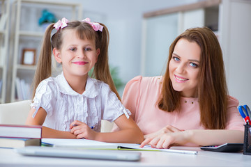 Obraz premium Mother helping her daughter to do homework