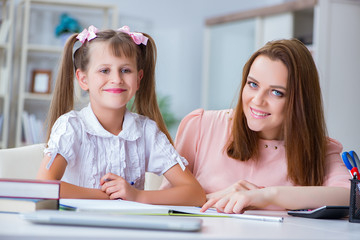 Mother helping her daughter to do homework