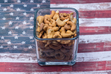 Cashew nuts in clear glass on USA flag background