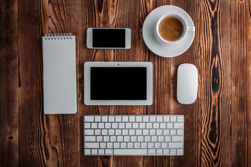 the white open notepad and computer keypad, mouse, mobile, coffee isolated on the wooden desktop