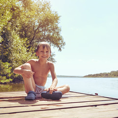 Young boy swimming and sunbathing during summer holidays, image with square aspect ratio and warm...