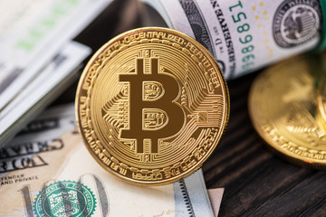 golden bitcoin coin on us dollars close up. Electronic crypto currency