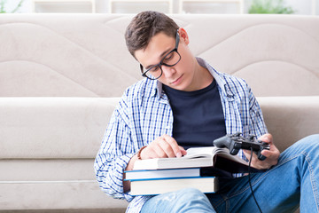 Fototapeta premium Young student trying to balance studying and playing games