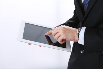 Unknown businessman holding digital tablet in office