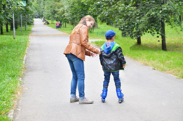 Father teaching son scating on rollers in the park