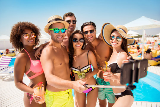 Diversity sunbathing sunshine tanned happiness eyewear spectacles cell cellphone modern technology video call concept. Group of excited funky fashionable amusing joyful teens taking selfie