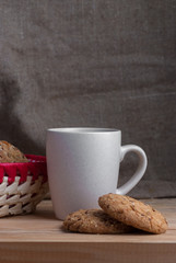 Oatmeal cookies with sunflower seeds near cup of tea.
