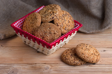Savory cookies sprinkled with sesame seeds, sunflower on table and burlap background