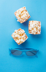 Popcorn with 3d glasses on blue background