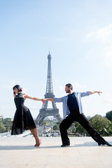 dance couple in front of eifel tower in paris, france. beatuiful ballroom dance couple in dance pose near eifel tower. romantic travel concept © be free