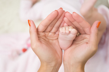 We are family. Baby foot in female hands. Mothers day concept. Family love and trust. Tiny little foot. Childhood and carefree concept. Support of parents. unity and protection